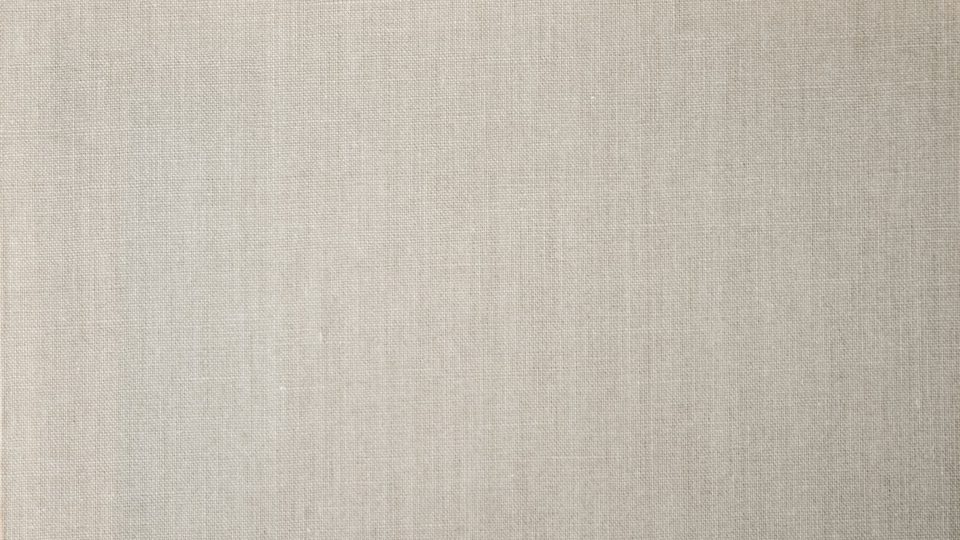 Close view of beige linen fabric in soft light.